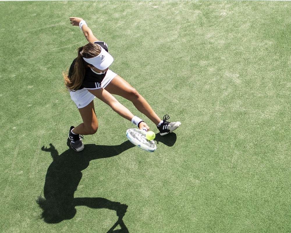Tennis player lunging for a low shot — a classic overuse motion behind tennis elbow — High Amplitude Health in San Mateo